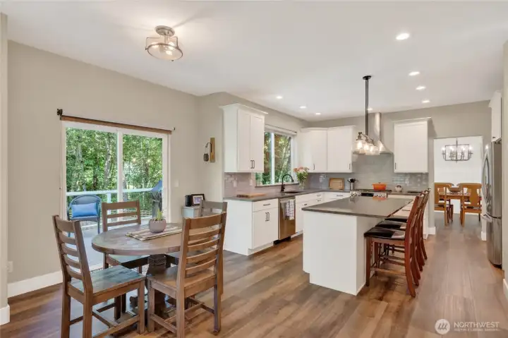 Kitchen opens to casual dining space, sliding door to outdoor living space.