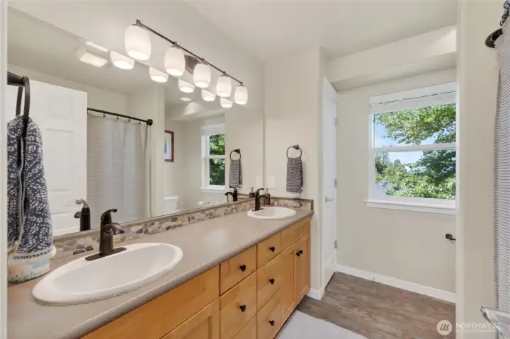 Secondary bath between third and fourth bedrooms. Well thought out with two sinks and linen closet for extra storage.
