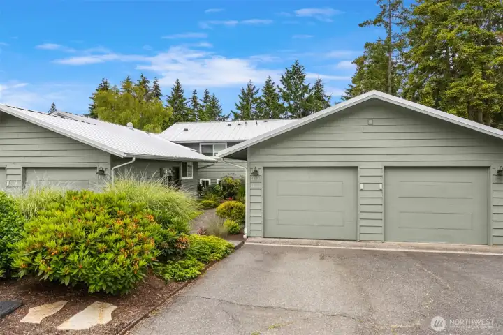 Notice the metal roof on this home. The attached 1 car garage is on the right. Additional parking spaces are out of view on the left. room for 3 cars.