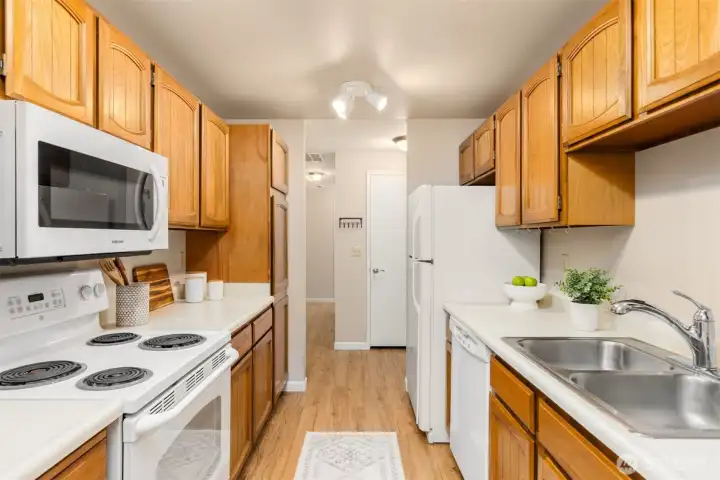 The gally style kitchen has abundant storage space with a pull-out pantry cabinet.