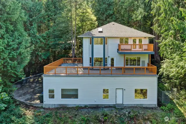 North (back) of home. Lower, L to R: Office, Door to Bonus Room, & Bonus Room. Main, L to R: Breakfast Nook, Door to Kitchen and Family Room. Upper, L to R: Primary Bath and Primary Bdrm w/French Doors to Balcony.