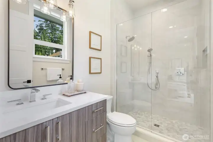 Ensuite bathroom features a floor-to-ceiling tiled shower stall with a built-in niche for storage.