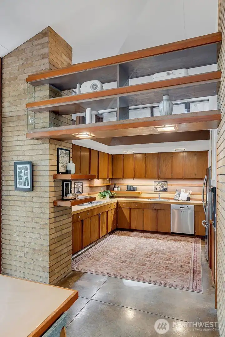 Clerestory bridge shelving separates the kitchen and dining area