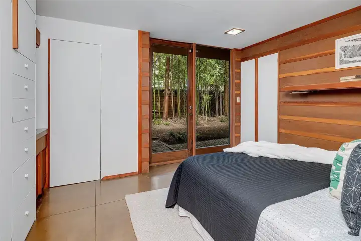 Primary suite with half bathroom and glass doors that open to garden space