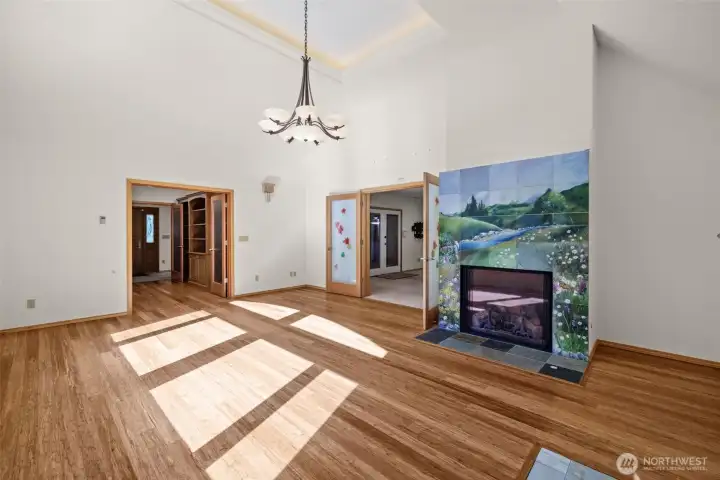Bright and Inviting Living Room Highlighted by Vaulted Ceilings and Custom Fireplace and hardwood flooring.
