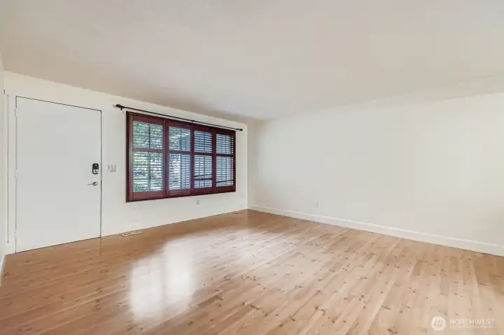 Open and bright formal living area with coat closet and linen closet. Engineered hardwood floors and fresh paint.