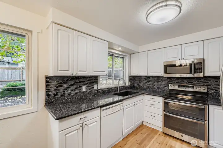 Updated kitchen with newer stainless appliances, granite counters, undermount lighting and extra deep sink.