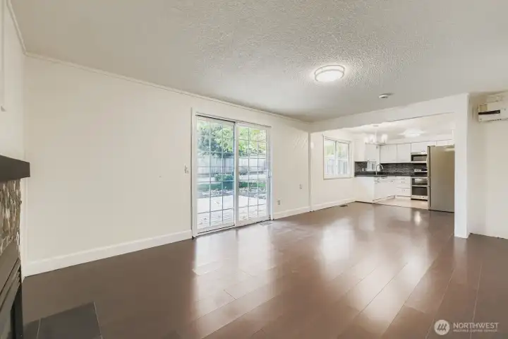 Family room with gas fireplace, engineered hardwoods, fresh paint and slider to BBQ deck and huge backyard. Adjacent laundry room and 1/2 bath combo.