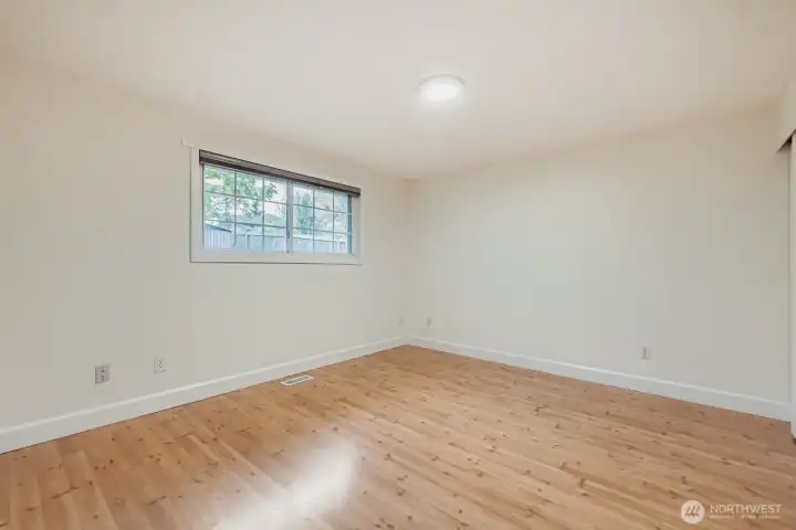 Primary bedroom with adjacent full bath, large cloest, fresh paint, all new lighting and engineered hardwoods.