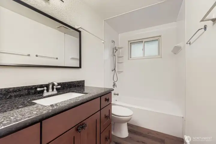 Full bath with shower/tub combo, granite counters and fresh paint.