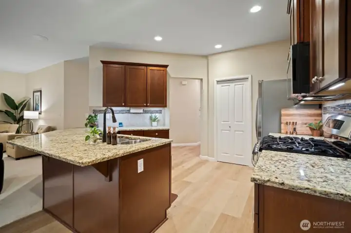 Slab granite kitchen with stainless appliances.