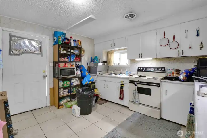 The kitchen, though small, is spacious, and contains the washer and dryer that belongs to the renters. The stove/range and refrigerator stay with the property.