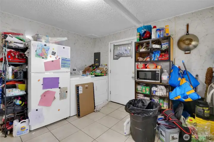 Facing the side door and fridge and washer/dryer. The tile flooring stands up to almost everything.