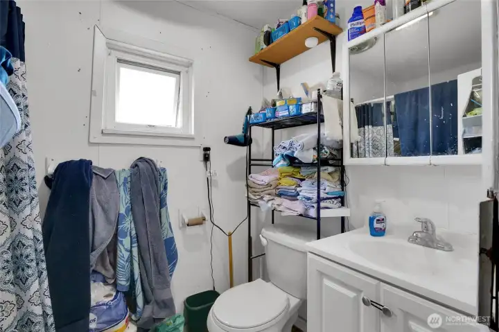 The full bathroom is at the back of the house, in the middle.  The bathtub and shower is behind the shower curtain.