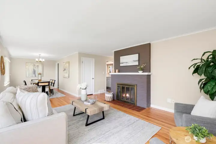 Welcoming living room viewed from the entry, with the cozy fireplace and warm, stylish staging.