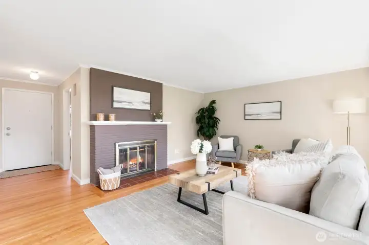 Inviting living room anchored by a wood-burning fireplace with a painted brick surround.