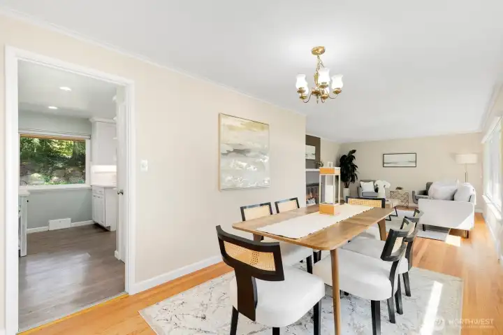 Open flow from dining to living room with a glimpse of the updated kitchen beyond.
