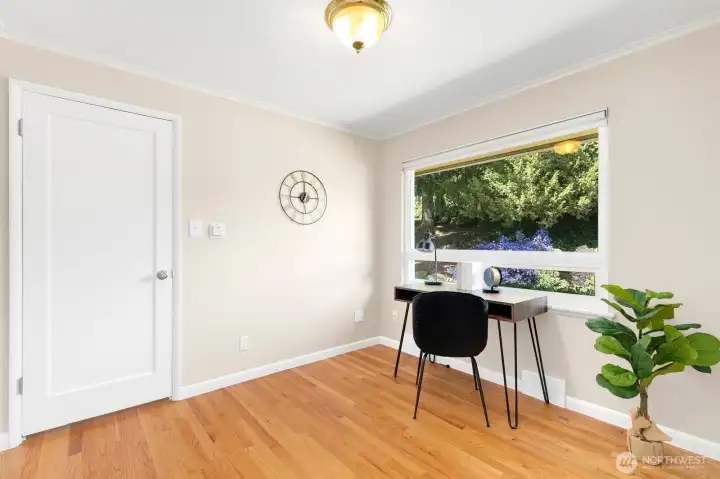 Flexible main-level den or office with hardwood floors and a garden-view window overlooking colorful plantings.