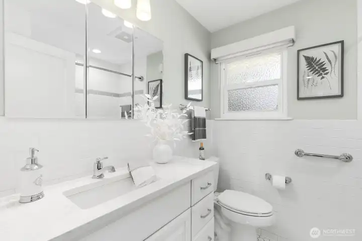 Beautifully refreshed full bath with white subway tile, new vanity, quartz countertop, and polished chrome fixtures.