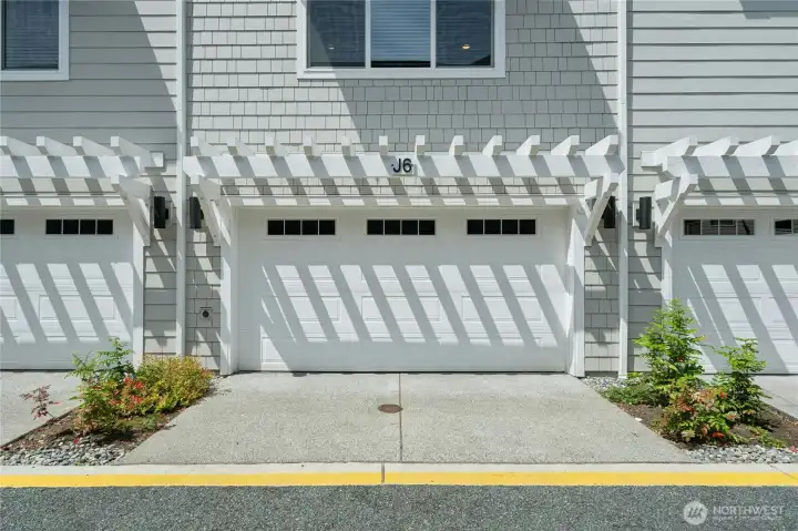 Attached two-car garage with EV charger and additional storage space.
