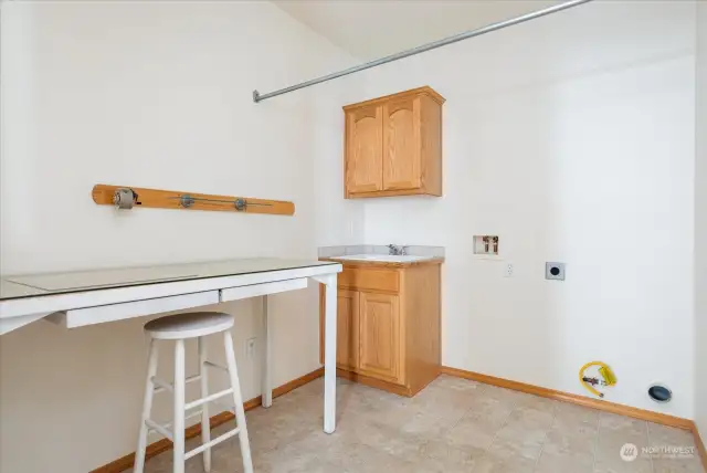 Large laundry room with work table included near garage.