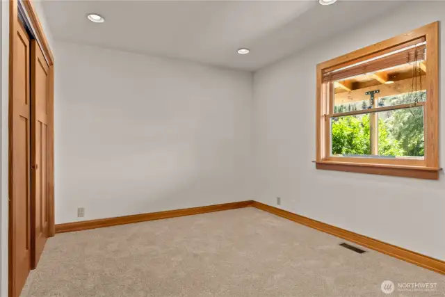 First floor bedroom with space for a queen bed and desk.