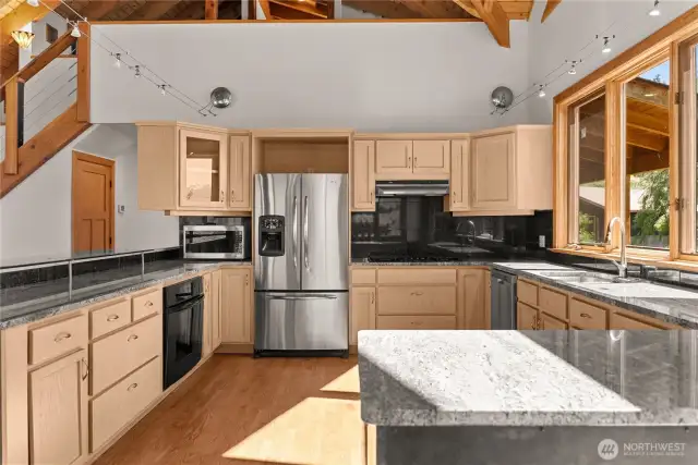 Inviting kitchen w/ lots of natural light. Granite counter tops & hardwood floors elevate the kitchen.
