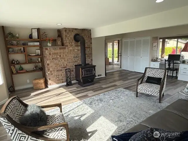 Great room with brick wall and built ins surrounding the wood stove that will keep you cozy in the winter