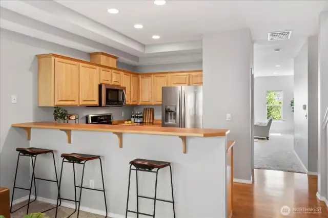 Into the kitchen. Lots of recessed can lights make this space bright and functional. Raised breakfast bar for seating for 3+