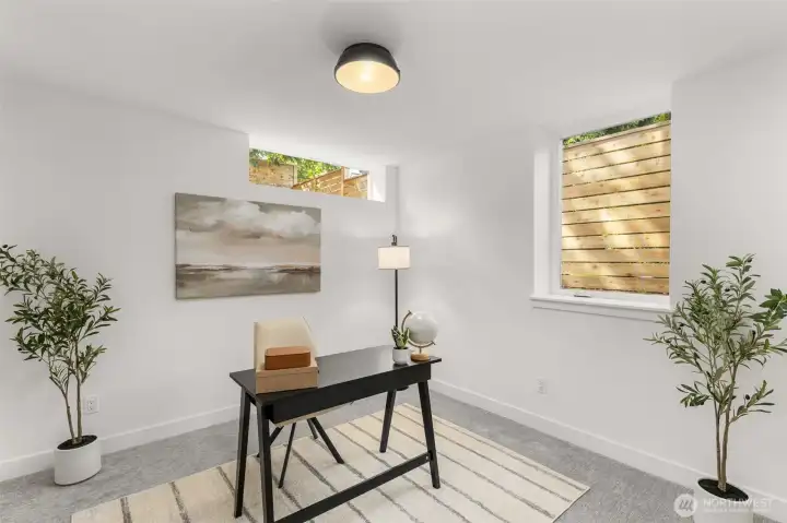 Secondary bedroom or office with large windows and a flexible, comfortable layout.