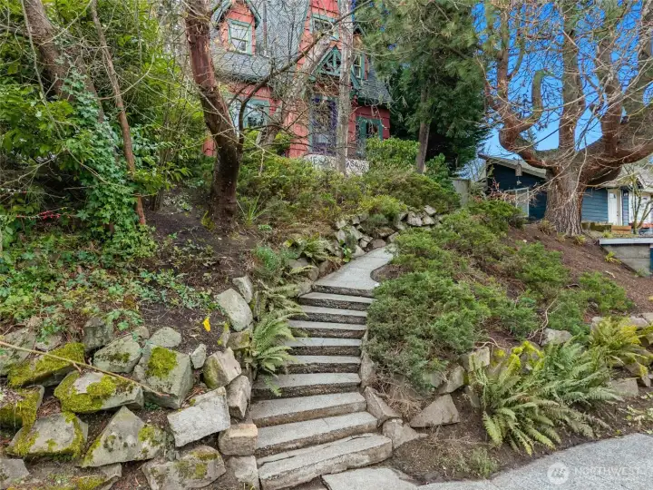 The winding stone path ushers you up to the home which is tucked into the lush landscaping. (Don't worry, there's level parking and entry in back!)