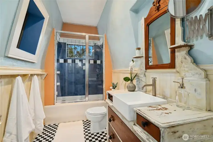 The rustic console vanity and vaulted ceiling add to the cohesiveness of the architectural design.
