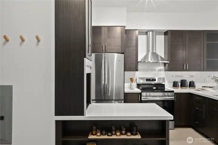 The heart of the home features quartz-stone countertops, a stainless steel appliance suite, custom wood cabinets, and an abundant pantry.