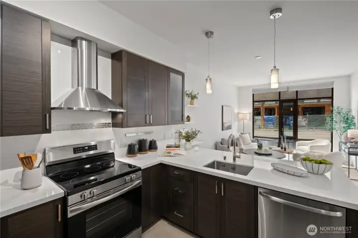 Designed for cooking and entertaining, this stunning kitchen offers quartz-stone waterfall counters, a deep commercial-grade undermount sink, stainless steel appliances, and wood cabinetry.