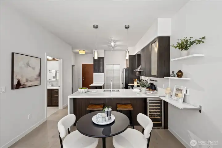 Sophisticated and functional, the kitchen showcases premium stainless steel appliances, custom wood cabinetry, a temperature-controlled glass-front wine cooler, and an extended counter-height bar for casual dining.