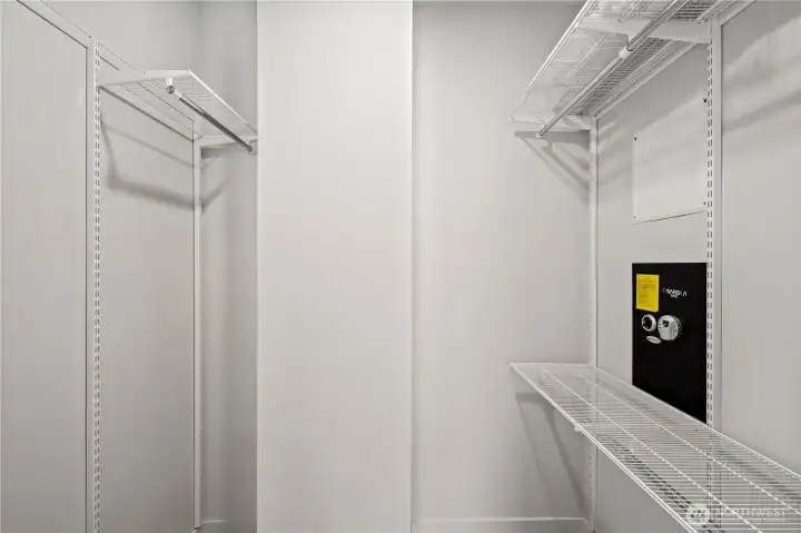 Walk-in closet featuring a customizable storage system and built-in electronic wall safe.