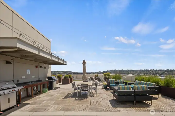 The spectacular rooftop deck features panoramic city, canal, and mountain views, an outdoor kitchen, BBQs, a fire pit, and gathering spaces.