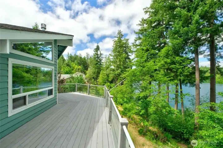 Another angle of the deck and grounds. The home is nestled on a shy quarter acre lot with approximately 60 feet of waterfront views & there is a community trail at the shoreline Another angle of the deck and grounds. The home is nestled on a shy quarter acre lot with approximately 60 feet of waterfront views & there is a community trail at the shoreline