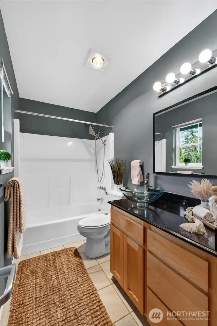 The attached primary bath features tile floors, quartz countertops and a bowl sink The attached primary bath features tile floors, quartz countertops and a bowl sink