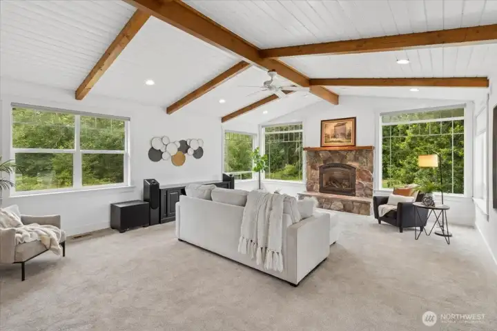 Stunning beams accent the high ceilings and flow toward the statement fireplace.