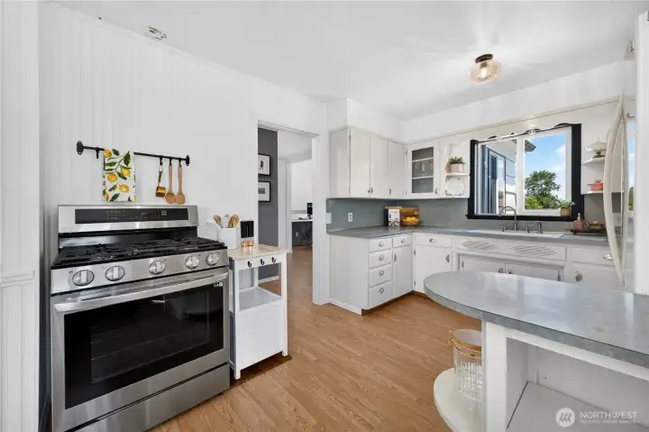 Kitchen: Vintage details include; wavy glass fronts, scallop detail above sink, and beadboard paneling.