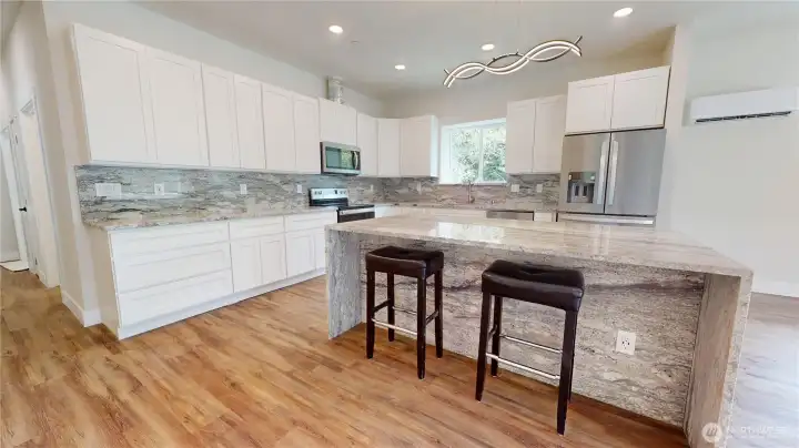 Beautiful White Cabs, w/Elegant Granite backsplash just under the Cabinets to Granite Counter top, Modern Lighting along with Recessed. 2 Mini Splits in this great Room, which you may not need with this energy efficient home, that can save up to 43% on heating bills.