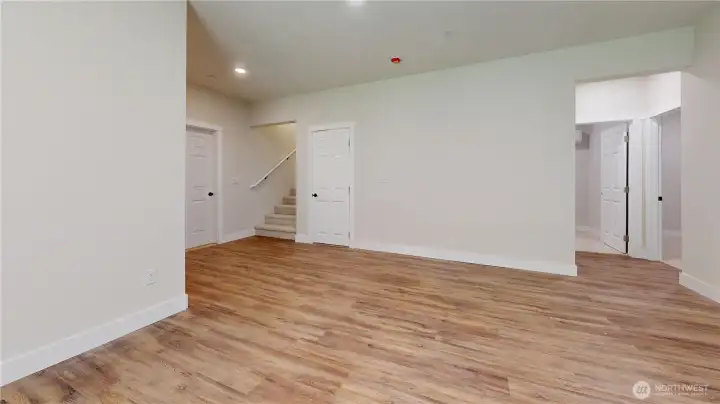 Lower Level Family  Room area with 2 Bedrooms to Right and Office Room and No Closet Straight ahead, Stairs to Main Level, Full Bathroom w/ Heated Floors to finish description also Door to Huge Garage!!