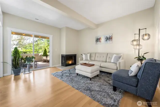 The spacious living room has a wood burning fireplace and sliding door with lovely views of the covered deck