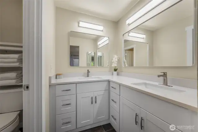 The primary bathroom was just updated with a new double vanity, quartz counters, and modern lighting