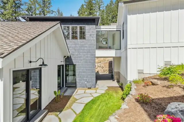Incredible custom architecture features a bridge to the upper level entry featuring a home office space.