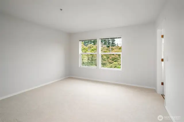 Generously sized master bedroom with sunlight streaming through windows