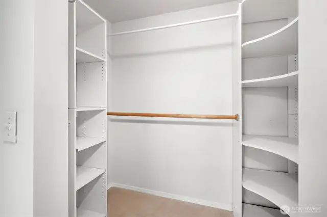 Primary walk-in closet with built-in organizers and shelving