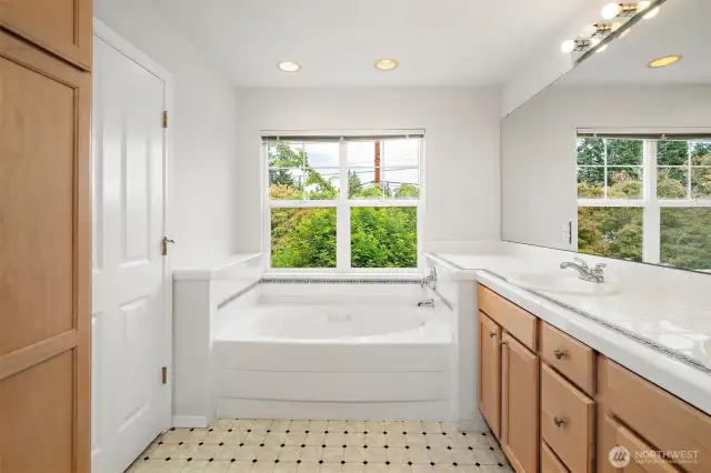En-suite featuring dual sinks and a deep soaking tub