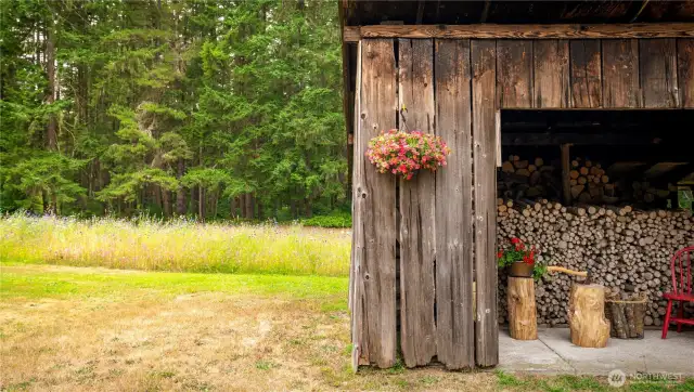 The property has numerous structures including this woodshed.